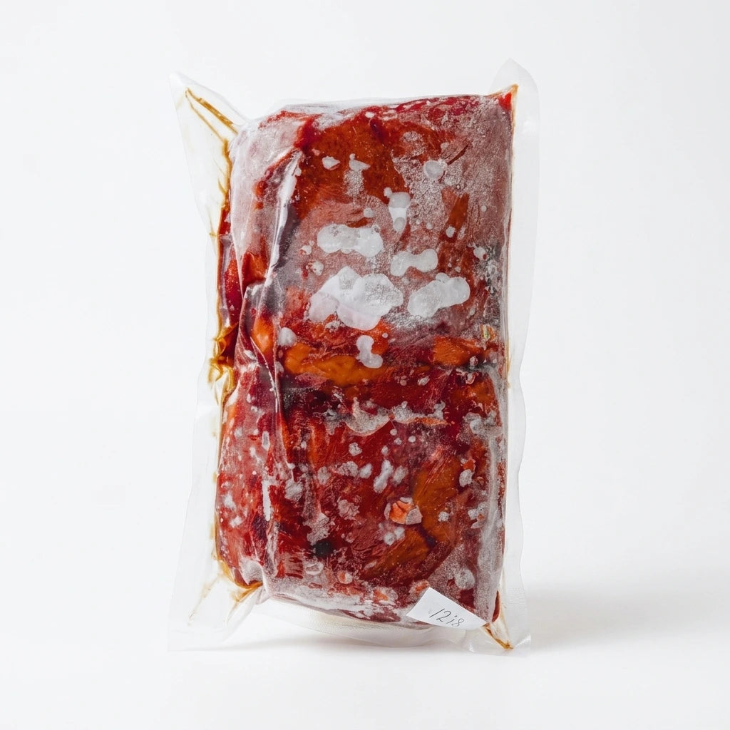 Frozen grass-fed beef liver vacuum sealed in a clear pack on a white background