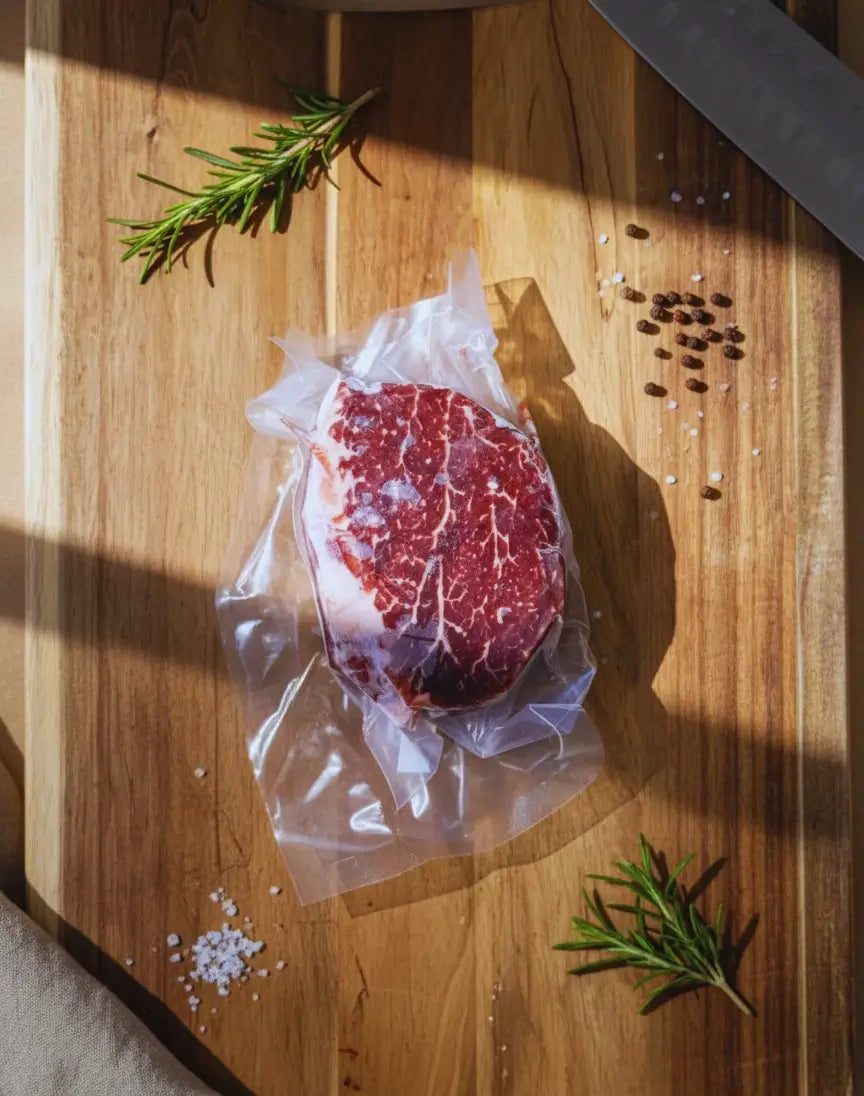 Diamond D Ranch vacuum-sealed marbled filet mignon steak on a wooden board with rich color and fresh appeal.