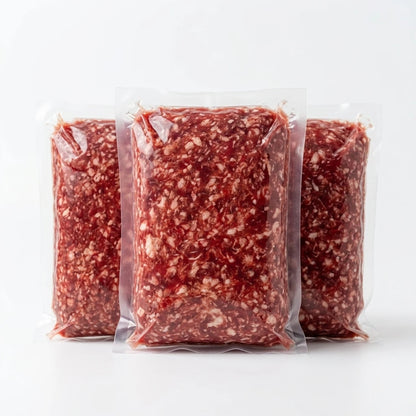 Three vacuum-sealed packages of ground meat, showing a marbled red and white texture, arranged on a clean white background.