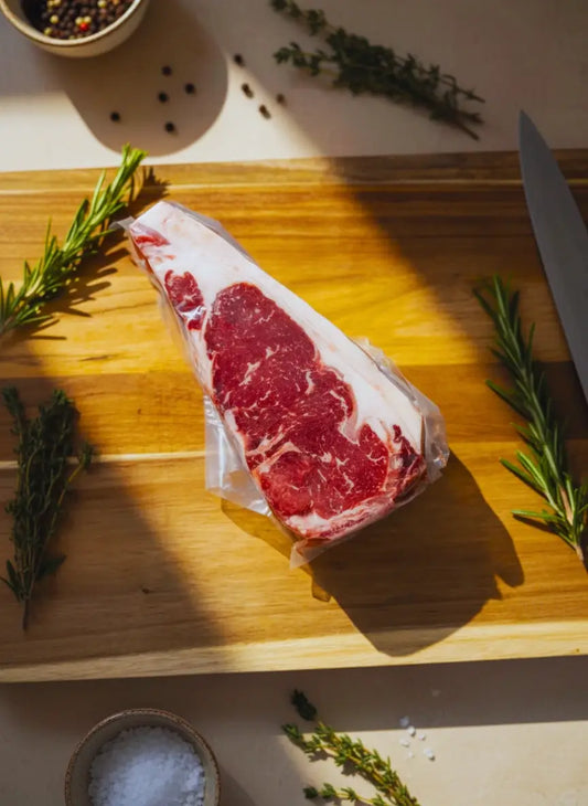 Diamond D Ranch vacuum-sealed ribeye steak on a board, showcasing rich marbling, and is ready for your grilled ribeye recipe.