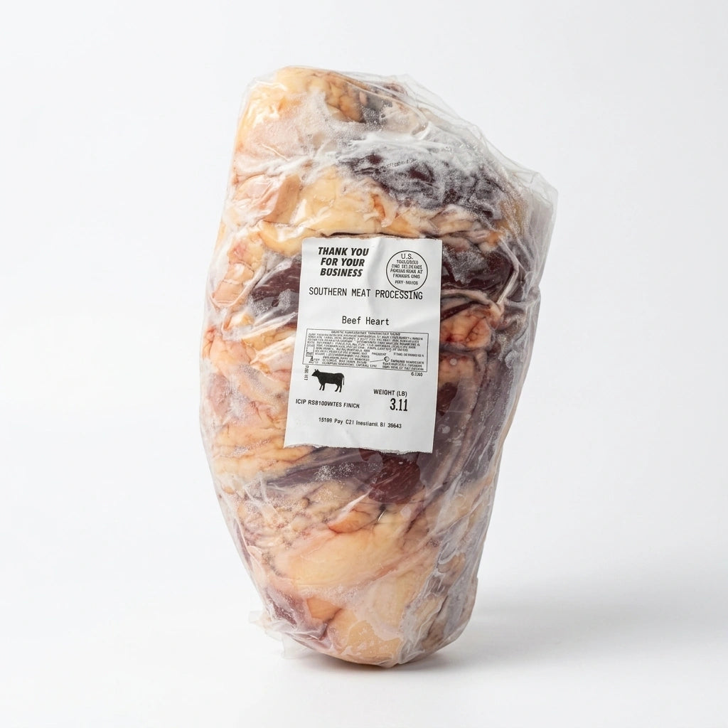 A large raw beef heart packaged in clear plastic wrap with a white label