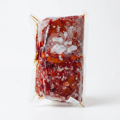 Frozen grass-fed beef liver vacuum sealed in a clear pack on a white background