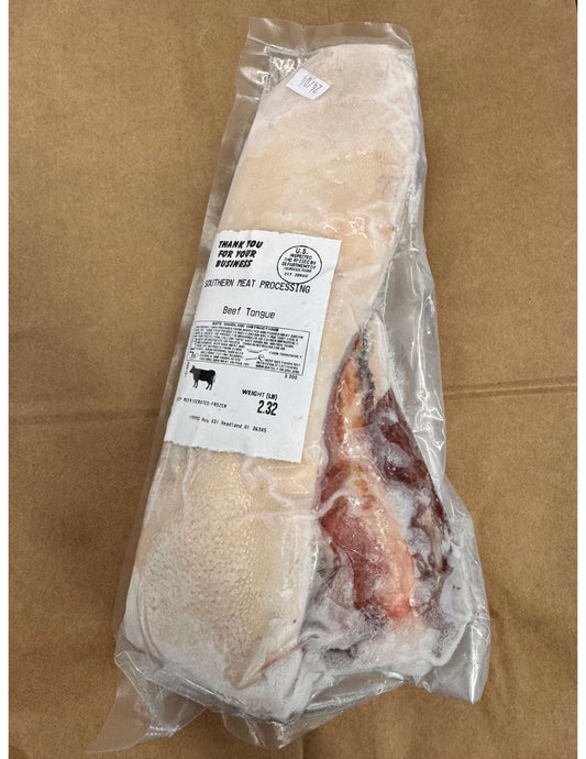 Frozen beef tongue in a vacuum-sealed package on a brown paper surface. The label reads "Southern Meat Processing" with weight details.