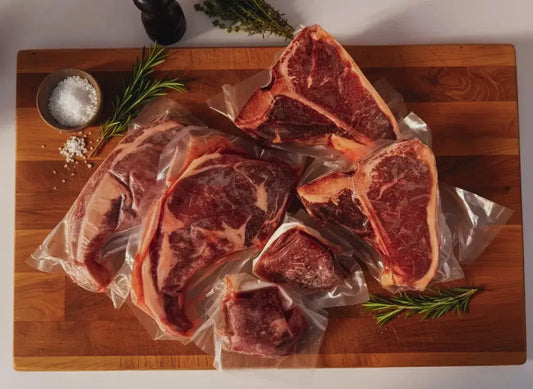 Diamond D Ranch Celebration Box: A restaurant steak, T-bone steak on a chopping board with salt and fresh herbs.