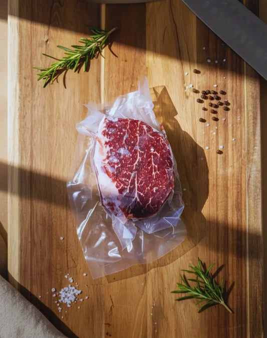 Diamond D Ranch vacuum-sealed marbled filet mignon steak on a wooden board with rich color and fresh appeal.