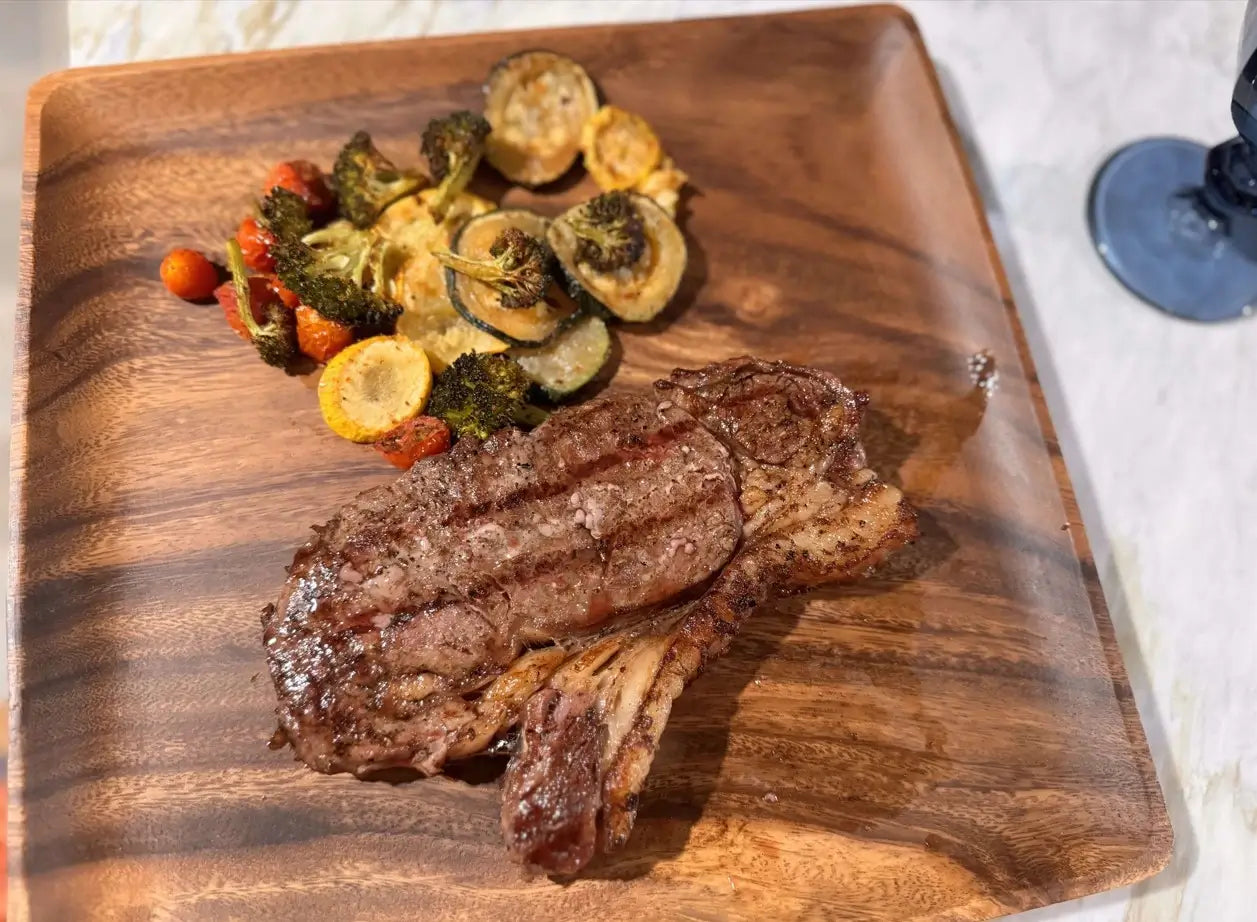 Diamondd D Ranch steak with roasted vegetables on a wooden cutting board